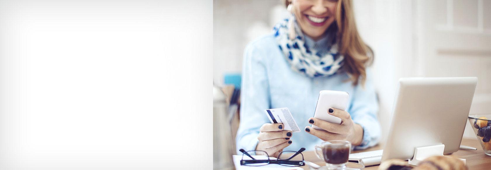 Woman using a debit card for a mobile transation. 微笑和快乐.